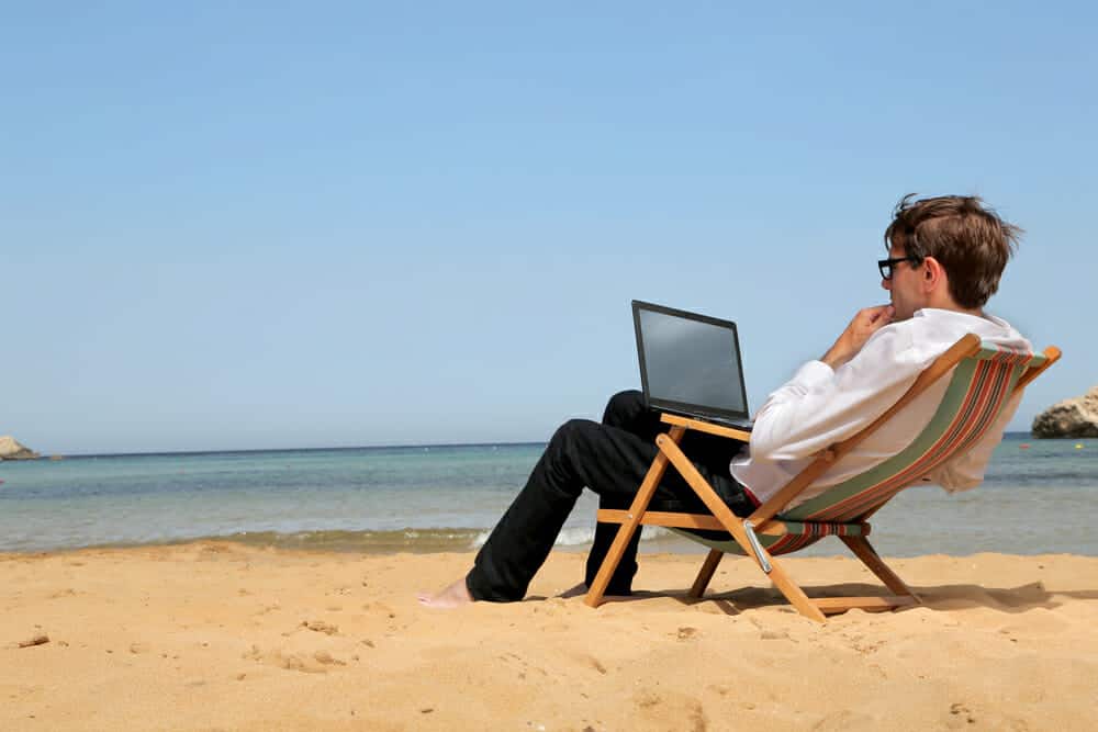 Picture of a marketer with his laptop on the beach - give me a break