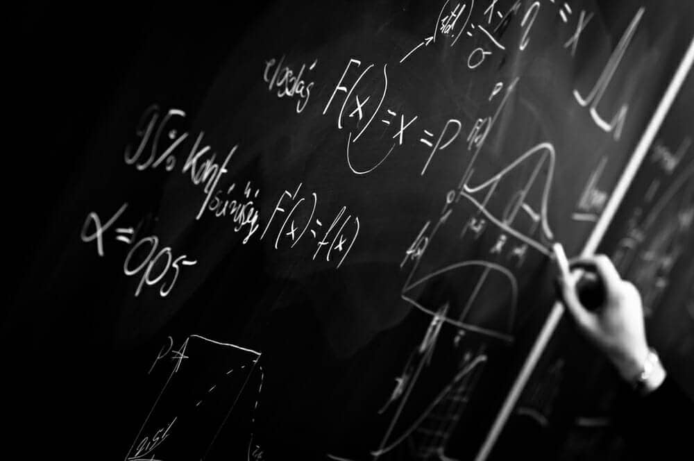 Person solving a mathematical formula on the chalkboard